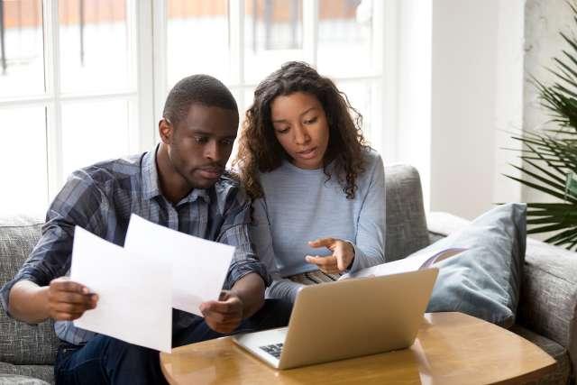 Couple at home looking for community resources on laptop