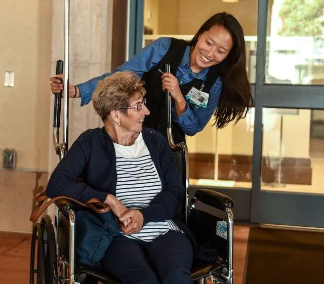 Nurse pushing woman in a wheelchair