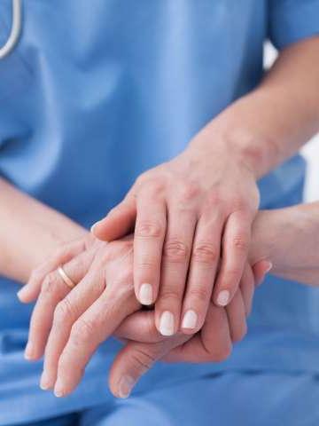 Close up of nurse touching the patient hand